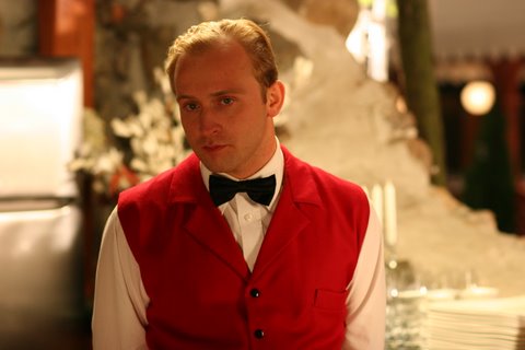 Borys Szyc jako kelner Tytus w scenie z filmu Testosteron