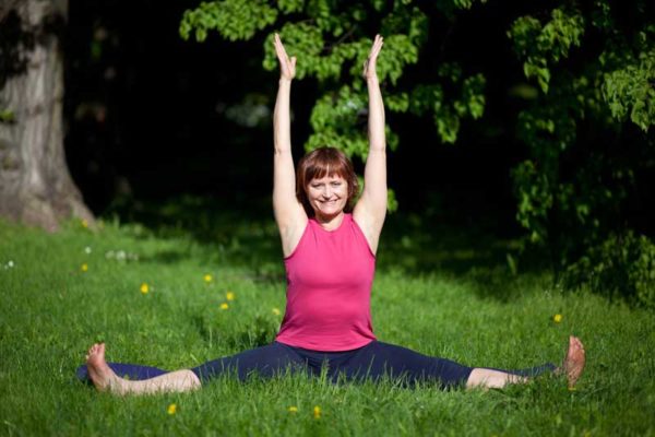 Kobieta na świeżym powietrzu na trawie ćwiczy jogę