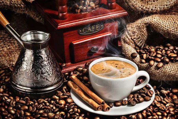 Filiżanka aromatycznej świeżo parzonej kawy w otoczeniu ziaren kawy