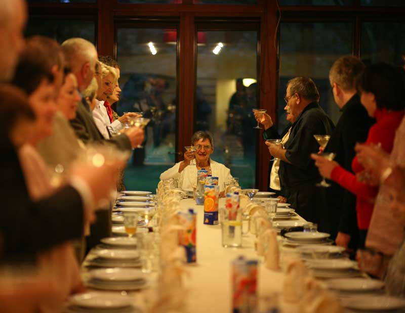 Rodzina wznosząca toast przy stole w Folwarku Badowo