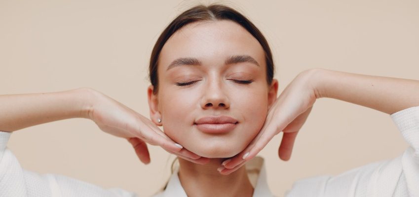 Young woman doing face yoga building facial gymnastics self massage